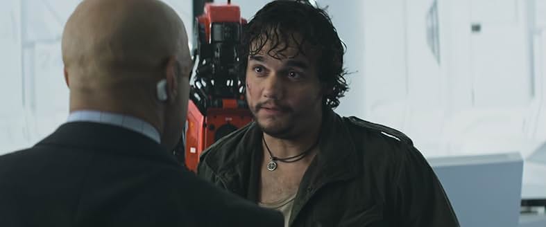 闇商人のスパイダー。数台のモニターに囲まれ、システムへのハッキングを試みている