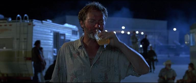 ボロボロの飛行服を着て、狂気じみた表情で叫ぶラッセル