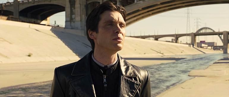 黒いロングコートを着て、冷徹な目でターゲットを追うレオン