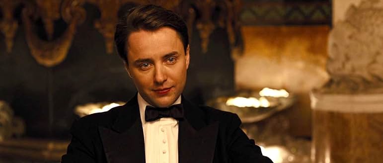 高級スーツに身を包み、冷ややかな表情を見せる大富豪フィリップ